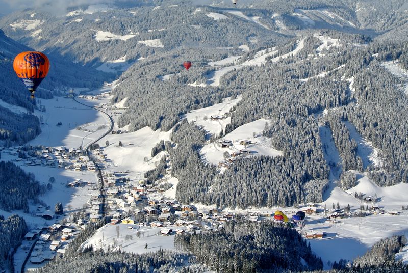 Výhled na balóny, které letí nad krásnou přírodou v Alpách