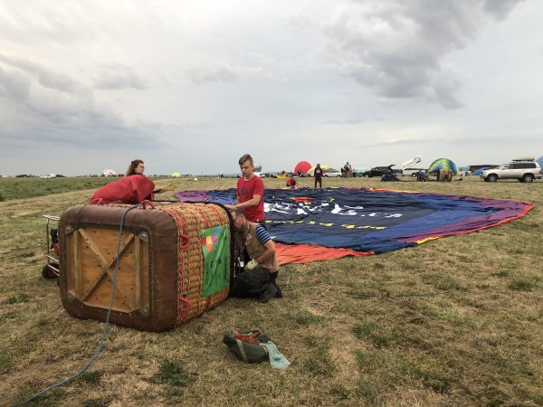 Muž s dítětem upravuje vnitřní část koše k balónu