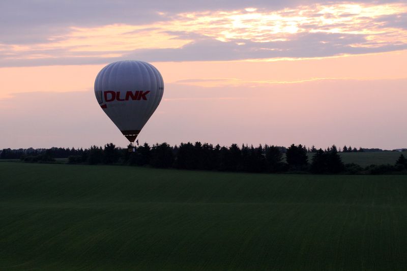 Bílý velký balón letící nad zemí